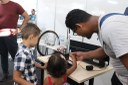 Pai leva filho e filha para ver experimentos de Física demonstrados na prática em estande do IFTO na Agrotins 2026